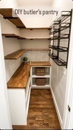 an empty walk in pantry with shelves and baskets on the counter top, next to a wooden floor