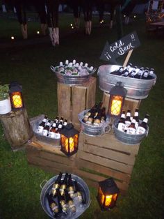 several buckets filled with bottles of wine sitting on top of a wooden pallet