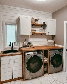 a washer and dryer sitting in a kitchen next to each other on top of cabinets