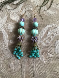 Aqua tassels and beads accompanied by Swarovski lavender crystals dangle from gold filled shepherd hooks. Purple Tassel Earrings With Dangling Beads For Gift, Gift Purple Tassel Earrings With Dangling Beads, Bohemian Purple Dangle Tassel Earrings, Elegant Lavender Beaded Earrings With Dangling Beads, Adjustable Purple Bohemian Tassel Earrings, Purple Beaded Earrings With Tassels For Gift, Elegant Adjustable Tassel Earrings With Round Beads, Elegant Handmade Purple Tassel Earrings, Handmade Elegant Purple Tassel Earrings