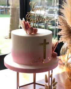 a pink and white cake sitting on top of a table