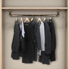 an open closet with clothes hanging on the rail and pants hanging off the rails in front