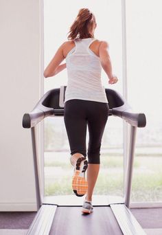 a woman running on a treadmill at the gym with her back to the camera