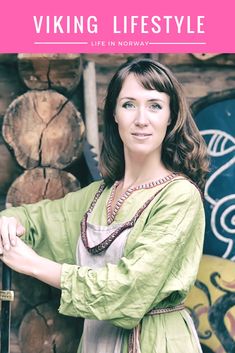 a woman standing in front of a pile of logs with the words viking life style on it