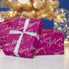 two wrapped presents under a christmas tree with lights