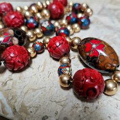 Light your fire this winter with this beautiful 28 inch 14 kt gold cinnabar and cloissone beaded necklace.  It has a marked 14 kt spring clasp w 48 gold beads, 7 round cinnabar beads, 12round cloisonne beads and 2 oval cloisonne beads on a gold chain.  Some of the gold beads are dented leading me to believe they are high quality gold as well.  Note the pictures.  A very classy necklace... This necklace is in stock and ready to ship immediately. Festive Red Artisan Jewelry, Festive Artisan Red Jewelry, Artisan Red Jewelry For Collectors, Unique Collectible Round Beads Jewelry, Traditional Red Jewelry For Collectible, Traditional Red Jewelry For Collectors, Artisan Red Collectible Jewelry, Artisan Red Necklaces With Spacer Beads, Vintage Red Single Strand Jewelry