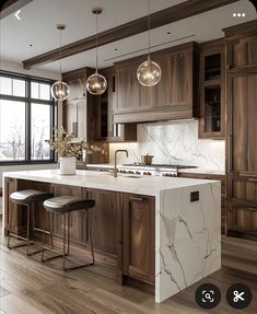 a kitchen with wooden cabinets and marble counter tops, two stools at the island