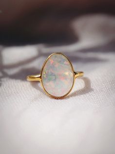 This bold gold statement ring features organic shaped Fire Opal that shines from within. This gorgeous gold ring is sure to become an everyday staple. Wear it solo or stack it with our other favorite rings.✦ DETAILS ✦✧ Name: Hinuhinu (HEE noo HEE noo) - bright, glittering, splendid.✧ Available in whole sizes 5-9. ✧ Synthetic Fire Opal Stone.✧ 18kt Gold Vermeil.✧ All Ke Aloha Jewelry pieces come packaged thoughtfully, beautifully, and ready for gift giving. Opal Ring Simple Gold, Opal Ring Simple Capucinne, Wide Band Ring Opal, Luxury Minimalist Yellow Gold Opal Ring, Natural Fire Opal Ring, Modern Opal Ring, Opal Statement Ring, Gold Moonstone Ring, Rings Sets