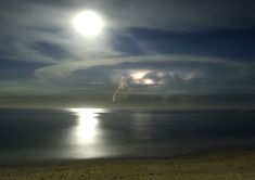 the moon is shining brightly over the ocean