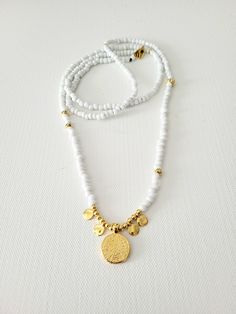 A summer beaded long necklace in white and gold colors. Trendy. Bohemian Chic. Perfect for layering. Description: * white and gold glass beads, also metal beads 24K gold plated brass * Phaistos coin pendant with dot charms, 24K gold plated brass * long necklace, 90cm length when open * toggle clasp closure. White Spiritual Necklace With Tiny Beads, Spiritual White Necklaces With Tiny Beads, White Spiritual Beaded Necklace With Tiny Beads, Spiritual White Beaded Necklace With Tiny Beads, White Spiritual Beaded Chain Jewelry, Gold Heishi Beaded Chain Jewelry, Gold Spacer Beads Jewelry For Summer, Gold Jewelry With Heishi Beads And Beaded Chain, White Multi-strand Beach Necklaces