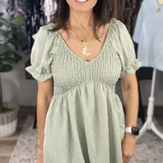 Loving This Sage Green Color And The Style Of This Dress. It Has A V-Neck. The Fit Is Precious With A Smocked Bodice And Puff Short Sleeves. The Bottom Of The Dress Is Lined. *Lined *Smocked Bodice *Puff Sleeves *Short Sleeves *V-Neckline V-neck Smocked Top With Smocked Bodice For Vacation, Casual Smocked Top With Gathered Neckline, Casual Smocked Flowy V-neck Dress, Casual Flowy Smocked Dress With V-neck, V-neck Flowy Smocked Dress For Brunch, Casual V-neck Flowy Smocked Dress, Casual Smocked Top With Gathered Neckline For Daywear, V-neck Smocked Dress For Daywear, Green V-neck Smocked Summer Dress