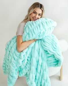 a woman is holding a large blue blanket