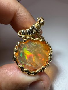 Handmade 14 karat Gold Solid Fire Opal Pendant Feline Weight Ring: 56.70ct  Opal Size: 16.6mm X 20.6mm X 5.9mm El Ópalo Mexicano, también conocido como el ópalo de fuego, es una gema fascinante y una de las piedras preciosas más representativas de México, especialmente de las minas en el estado de Querétaro. Este ópalo se caracteriza por su juego de colores vivos y llamativos, que van desde el naranja intenso hasta el rojo brillante, evocando la vivacidad del fuego. La belleza del ópalo mexicano Unique High Luster Round Jewelry, Unique Round High Luster Jewelry, Unique Round High-luster Jewelry, Pretty Accessories, Mexican Fire Opal, Bridesmaid Gifts Jewelry, Opal Jewelry, Bridesmaids Gifts, Fire Opal