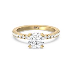 a yellow gold engagement ring with diamonds on the band and a single round diamond in the center