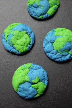 four green and blue cookies with the earth on them