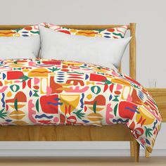 a bed with colorful comforter and pillows on it