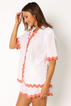 DETAILS   This season, don't forget to pack the perfect vacation-ready look. Our button down shirt is made with a v neckline and collared detail. Its short sleeves feature a vibrant melon contrast trim and hem, all while providing an oversized fit for maximum comfort.    button down shirt   v neckline  collared  short sleeves  melon contrast trim and hem  oversized fit  unlined   material - 52% cotton / 48% linen    SIZING    model is 5' 8" and wears a Size S  model stats: bust -  86  cm, waist Summer V-neck Shirt For Vacation, Orange V-neck Shirt For Summer, Orange V-neck Summer Shirt, Summer Orange V-neck Shirt, White V-neck Beach Shirt, Orange Collared Tops For Summer, Orange Vacation Shirt For Spring, Orange Shirt For Spring Vacation, Orange Spring Vacation Shirt