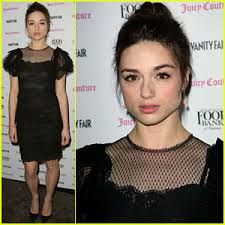 an image of a woman in black dress at vanity magazine party with her hair pulled back