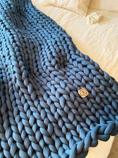 a large blue blanket sitting on top of a bed