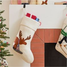 two christmas stockings hanging on the wall next to a fireplace