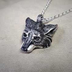 This piece will be handmade for you in the United Kingdom. Please allow me up to 28 days to finish making it. This Silver Wolf has been hand made in the United Kingdom. Grey wolves (Canis lupus), are found in various guises throughout remote areas of the Northern Hemisphere. They have been an essential element in the folk law and literature of almost all cultures and ages.She-wolves are the epitome of maternal protection and feminine strength, they were particularly prevalent in Roman legend and also the title given to England’s war-like medieval queens. The sterling silver wolf measures around 2.5cm (which is close to an inch). It has eyes made from natural, cabochon cut, 4mm grey moonstone gemstones. The silver wolf has been hung from an elegant, yet sturdy 20 inch long solid silver chai Silver Wolf Pendant Necklace, Silver Wolf Design Round Pendant Necklace, Silver Necklace With Wolf Design Round Pendant, Silver Round Pendant Necklace With Wolf Design, Sterling Silver Wolf Design Jewelry, Silver Wolf Design Pendant Necklace, Moonstone Eyes, Grey Wolves, Feminine Strength