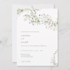 a wedding card with watercolor flowers and greenery on the front, in white