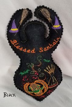 this is an image of a hand made black bag with embroidered words and images on it