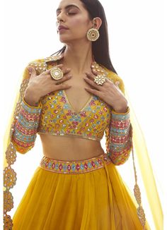 Step into elegance and radiate confidence with our Mustard Yellow Applique Lehenga Set. This exquisite ensemble features a beautifully hand-embroidered blouse adorned with stunning applique work. The skirt, crafted from luxurious silk organza, is enhanced with a mesmerizing mirror border that adds a touch of glamour. Complete the look with the matching dupatta, and you'll be the epitome of grace and style. Perfect for weddings, festivals, or any special occasion, this Lehenga Set from Vani is a true masterpiece that will make heads turn. Composition : Lehenga and Dupatta - Organza, Blouse - Georgette, Lining - Silk Blend Care: Dry Clean Only and Vacuum Storage This product can be customized for sleeves, length of blouse and neckline Delivery : 6-8 weeks as the product is hand crafted. Chec Traditional Hand Embellished Chanderi Sharara, Embellished Tissue Silk Saree Set, Hand Embellished Georgette Saree Sets, Hand Embellished Chanderi Sharara For Wedding, Elegant Embellished Chanderi Lehenga, Fitted Hand Embellished Organza Lehenga, Semi-stitched Hand Embellished Sets For Diwali, Hand Embellished Fitted Organza Lehenga, Navratri Semi-stitched Hand Embellished Choli