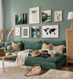 a living room with green walls and pictures on the wall above the couch, along with other furniture