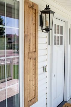 the front door is open and there are two lights on the side of the house