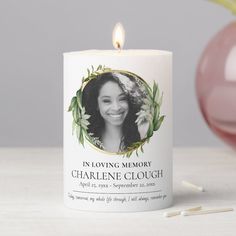 a personalized candle with a photo on it next to some matches and a pink ornament