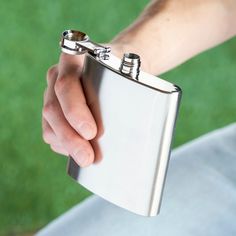 a person holding onto a flask with two rings on it