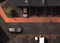 an overhead view of a parking lot with two cars parked on the street and one person walking