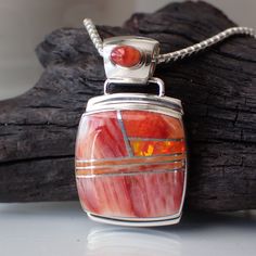 This stunning sterling silver pendant is created and stamped by Navajo artist Marie Tsosie. It features an inlay design of red spiny oyster and fire opal. The pendant measures 1.2" long including the bail by .7" wide. The interior dimension of the bail is 4 mm. The chain is sold separately. Inlay Design, Inlay Jewelry, Spiny Oyster, Opal Pendants, Native American Jewelry, Box Chain, Turquoise Jewelry, Artist Art, Sterling Silver Pendant