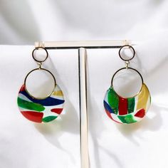 Elevate your style with the vibrant and unique Primary Delight Dangle Earrings. Handmade with love and precision, these earrings feature high-quality polymer clay in bold, primary colors that add a splash of joy to any outfit. The 18k gold plated accents provide a touch of elegance and sophistication, making these earrings perfect for both casual and formal. Each pair is meticulously crafted by hand, ensuring that no two pairs are exactly alike. Premium polymer clay and 18k gold plated accents f Bold Resin Jewelry For Gifts, Bold Resin Jewelry For Gift, Modern Multicolor Dangle Jewelry, Handmade Bold Resin Jewelry, Bold Handmade Resin Jewelry, Modern Resin Jewelry For Party, Modern Resin Jewelry For Parties, Colorful Earrings As A Gift, Bold Drop Earrings With Bold Design