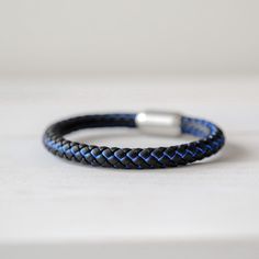 a close up of a bracelet on a table Casual Blue Durable Bracelets, Modern Blue Leather Bracelet, Casual Black Braided Bracelets For Outdoor, Modern Adjustable Blue Braided Bracelets, Modern Adjustable Blue Braided Bracelet, Adjustable Blue Braided Bracelets For Outdoor, Slide Lock, Fits Men, Men's Bracelet