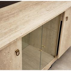 a cabinet with glass doors on the front and bottom, is shown in beige marble