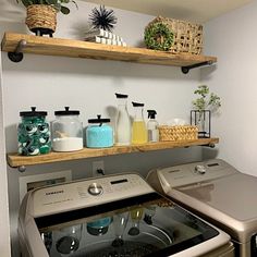 a washer and dryer in a small room with shelves above the washer