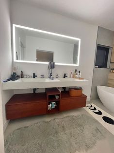 a bathroom with a sink, mirror and bathtub in it's center area