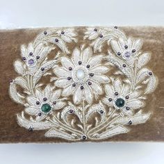 "A handbag with luxurious textures - soft brown velvet handbag hand embroidered with white silver floral wreath embellished with genuine semi precious gemstones including a moonstone and amethysts. The perfect purse to wear with with faded jeans, tweeds, large oversize ivory sweater, camel color. Expertly hand embroidered by master zardozi artisans. The word Zardozi means \"gold thread\". It is an elaborate embroidery art form using metallic threads and genuine semi precious stones to create a r Elegant Embroidered Ceremonial Bags, Luxury Evening Bag With Intricate Embroidery, Luxury Evening Bag With Intricate Embroidery For Formal Events, Luxury Formal Evening Bag With Intricate Embroidery, Elegant Rectangular Ceremonial Bag, Elegant Rectangular Ceremonial Bags, Elegant Ceremonial Rectangular Bags, Luxury Embroidered Beige Evening Bag, Luxury Beige Embroidered Evening Bag