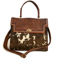 Featuring a gorgeous chiseled artisan design, this hair on leather bag will help you bring a little western flair to your everyday outfit. The perfect size for fitting all of your everyday essentials, this purse was actually handmade with love and care  with  talented  artisans  giving it a rustic touch that's hard to find in stores.  Crafted from genuine cowhide leather and best for casual and everyday wear.  height: 23cm. 9 inches width : 28cm.  11inches  base: 12cm.    4.5  inches  Adjustable Western Style Brown Bags For Daily Use, Western Hand Tooled Bags For Daily Use, Western Hand Tooled Travel Bag, Western Hand-tooled Bag For Daily Use, Western Style Hand Tooled Shoulder Bag For Travel, Western Style Hand-tooled Bags For Everyday Use, Western Style Hand-tooled Bag For Daily Use, Western Style Hand-tooled Travel Bag, Western Style Hand Tooled Brown Shoulder Bag