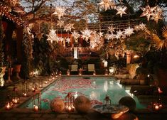 an outdoor pool with candles and decorations around it