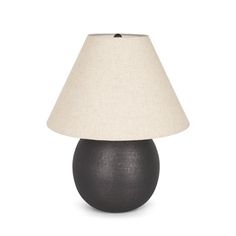 a black table lamp with a white shade on the base and a beige linen lampshade