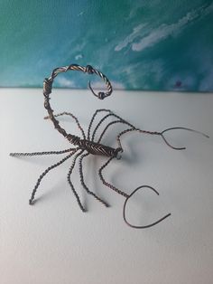 a wire spider sculpture sitting on top of a table