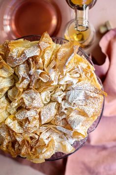 a bowl filled with powdered sugar next to two glasses