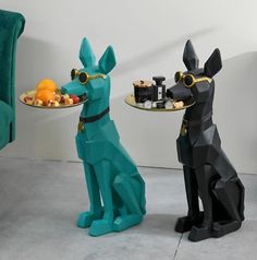 two dog statues sitting next to each other holding trays with food on them