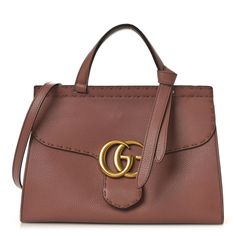 This is an authentic GUCCI Calfskin Small GG Marmont Top Handle Bag in Rosy Phard.This shoulder bagis crafted of lovely textured calfskin leather in a dusty rose pink. It features a matching leather top handle with an optional removable shoulder strap. The front crossover flaphas an interlocking GG logo, that opens to a natural fabric interior with zipper and patch pockets. Dusty Rose Pink, Gg Logo, Natural Fabric, Gg Marmont, Handle Bag, Natural Fabrics, Rose Pink, Leather Top, Dusty Rose