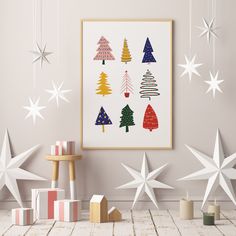 an art print with christmas trees and stars hanging from the ceiling in front of a wooden table