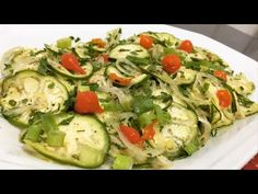 a white plate topped with cucumbers and tomatoes