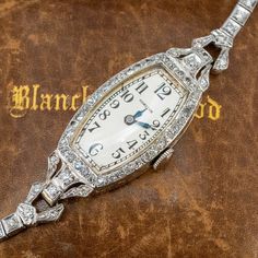 This exquisite circa 1930s Hamilton wristwatch (Style No. 989) features a diamond accented case and bracelet. The case is by the Wadsworth Watch Company (Case No. 0138038) and engraved details accent the side faces of the case and lugs. The case, lugs and bracelet are accented with a total of seventy- seven (77), bead set, round single cut diamonds. The case measures 16.5mm wide and 8.0mm thick. The silver colored dial features black Arabic numeral hour markers and blue steel hands. The movement Antique Costume Jewelry, Vintage Watches Women, Peridot Jewelry, Watches Luxury, Old Watches, Ladies Watches, Antique Watches, Watch Bracelet, Bead Set